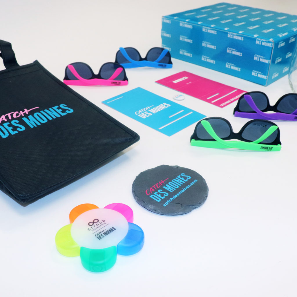 Catch Des Moines promotional items including: bag, sunglasses, box, flyers, cups, highlighter