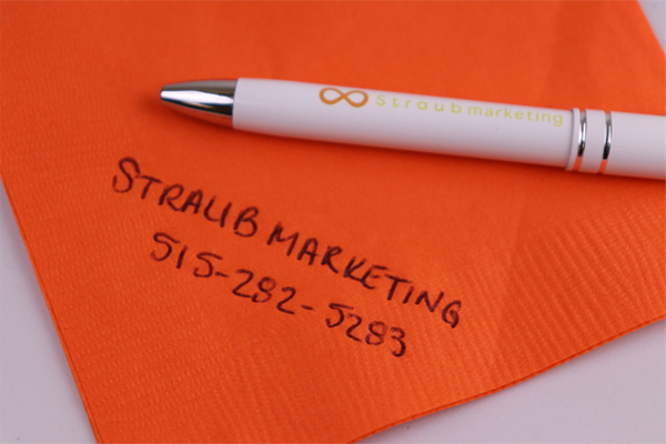 Straub Marketing on orange napkin with promotional pen